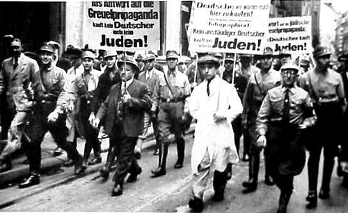 Jews Forced to Carry
Anti-Semitic
Signs